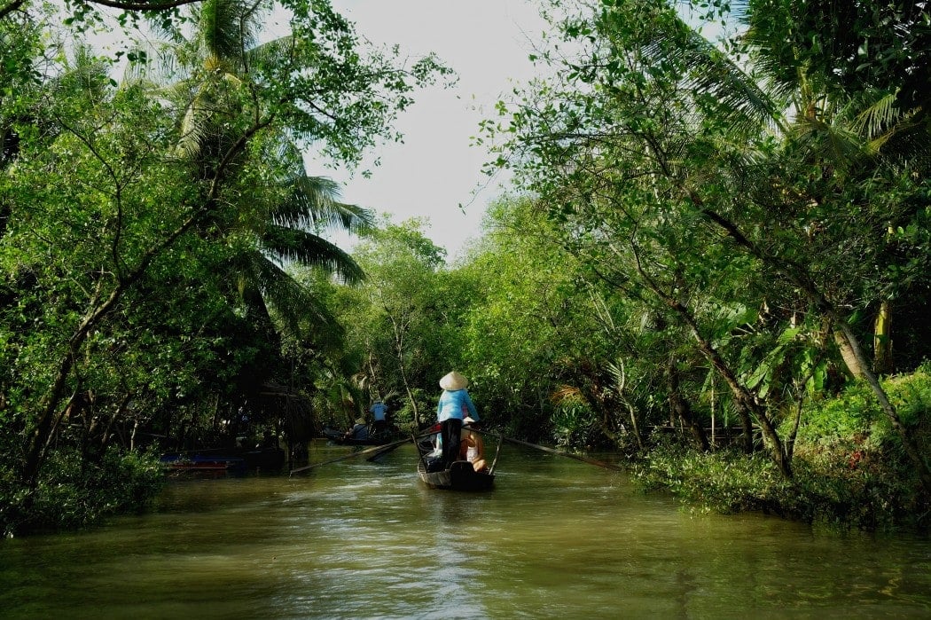 Tourists take a boat ride down the Mekong Delta while visiting Vietnam