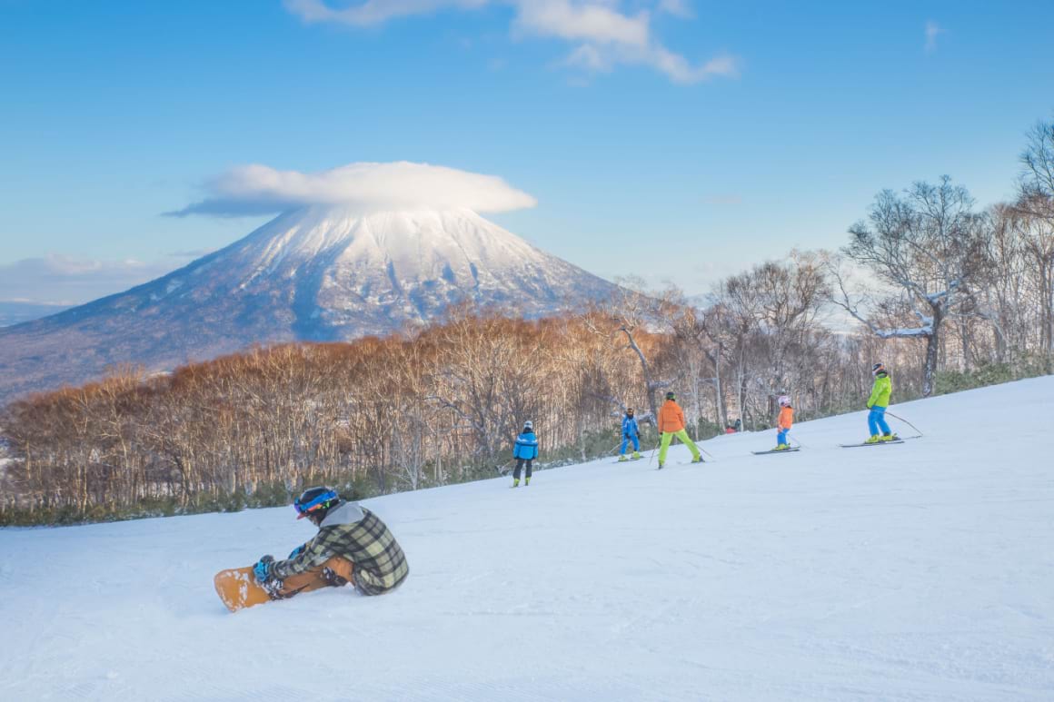 Group of kids skiing in the Japanese Alps with mountain views in the background