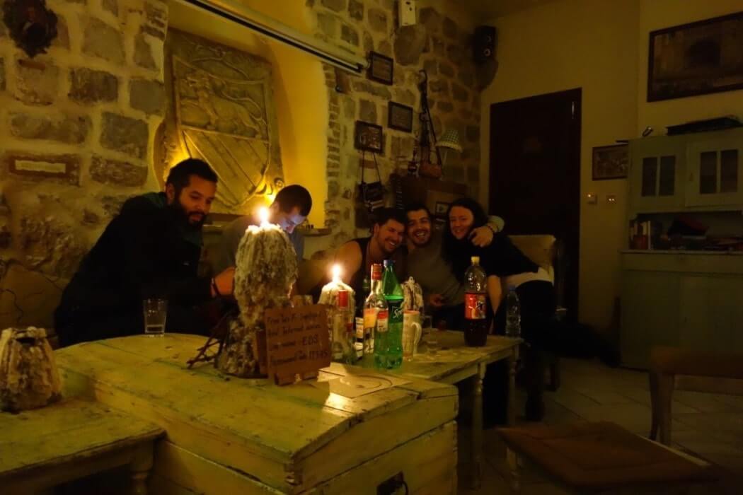 will, clair and friends having drinks in an old stone walled house in croatia
