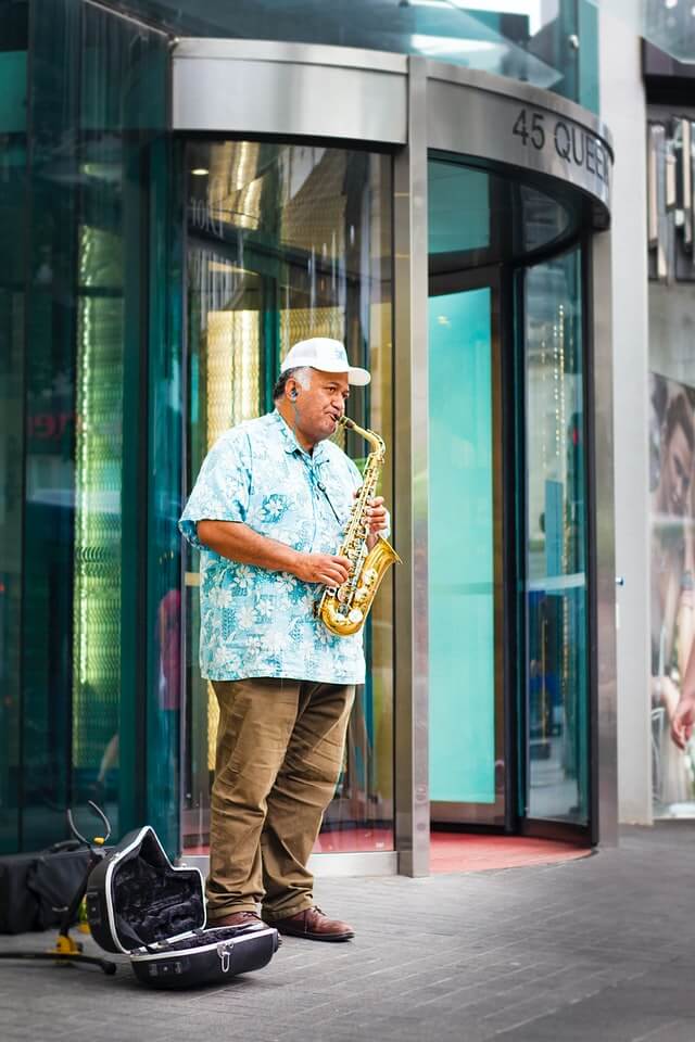 Saxophone playing traveller Kiwi busking in Queen Street, Auckland