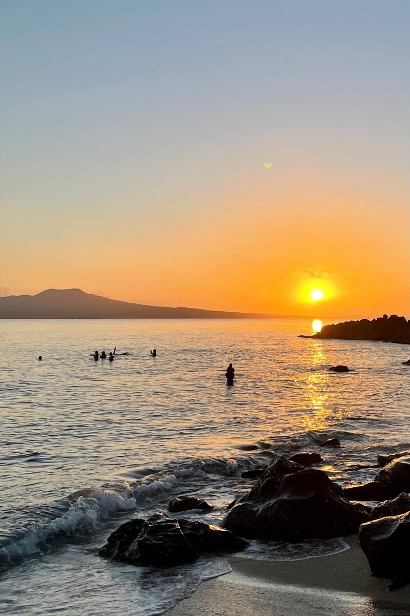 thorne bay in auckland, new zealand at sunrise looking over to rangitoto island