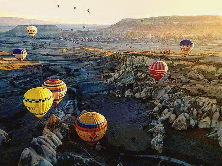 Hot air balloons at sunset in a field in Turkey. 