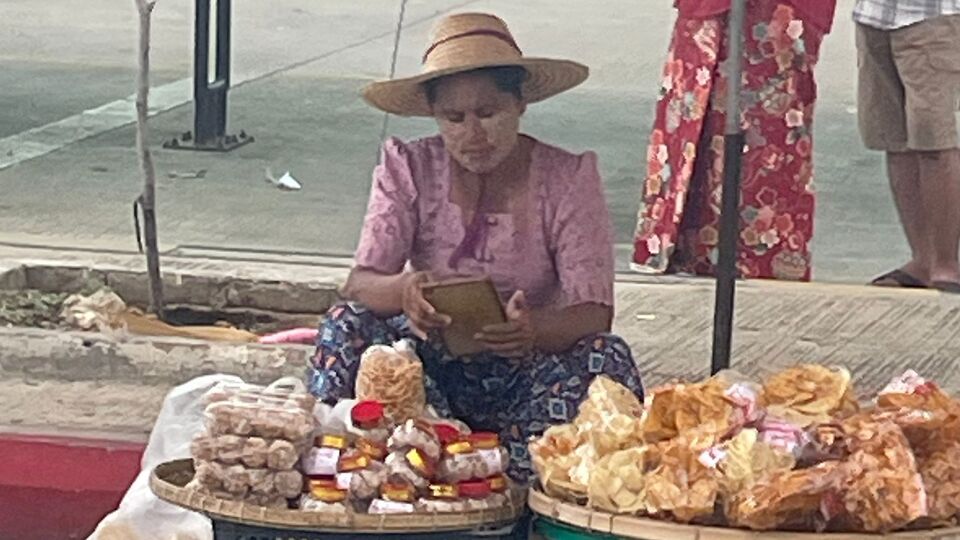 A woman selling food at a street market in Yangon, Myanmar.