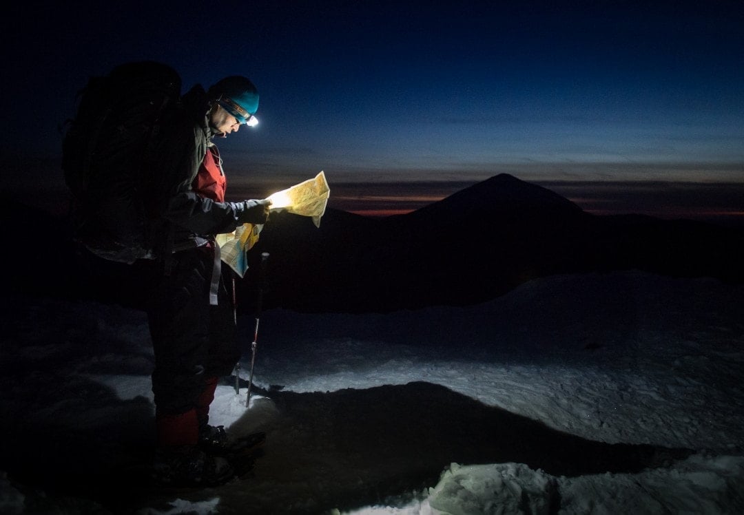 Man hiking with a headlamp - a backpacking essential