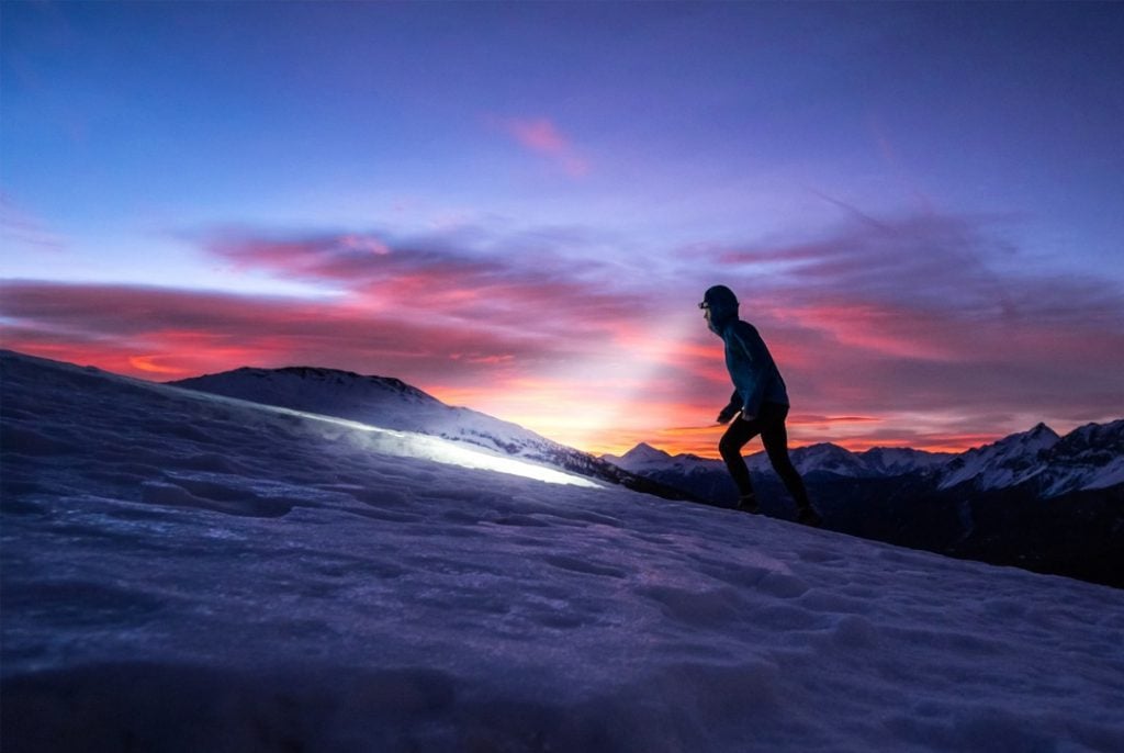 A man RV camping goes hiking at dawn with a headtorch