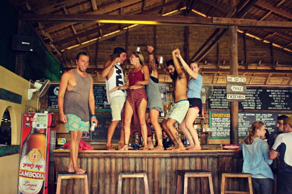 Young backpackers dancing on a bar whilst partying in Cambodia, Southeast Asia