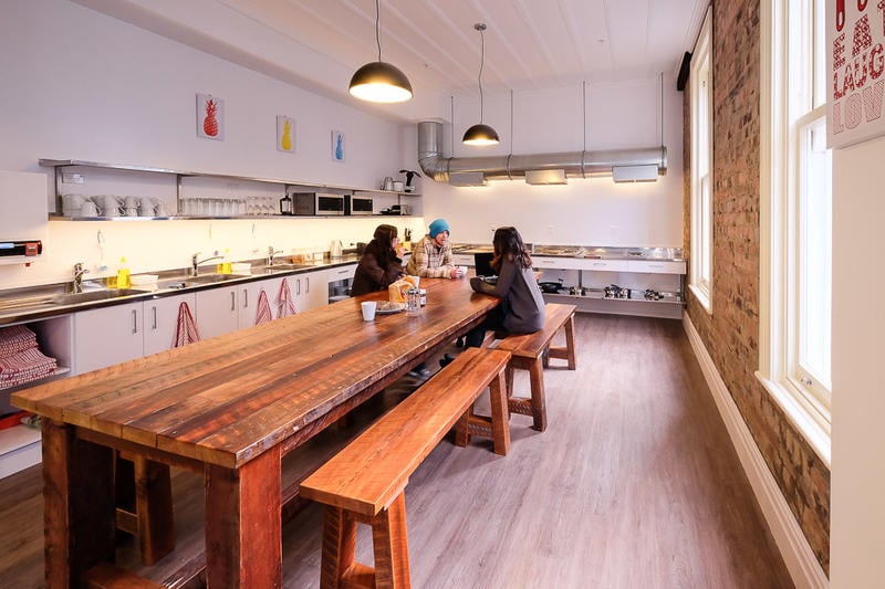 Haka Lodge Auckland best hostels in Auckland big kitchen and dining table with friends having a cuppa