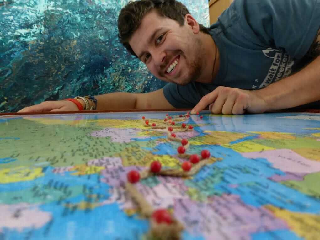 young will hatton laying on a paper map marked with stops on his overland travel plans