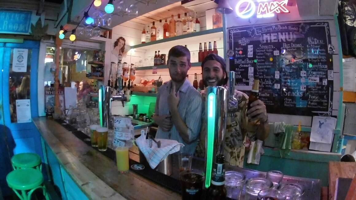 Two guys working in a bar as bartenders. 