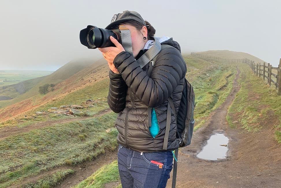 Nic taking a photo on Mam Tor mountain in the peak district, UK