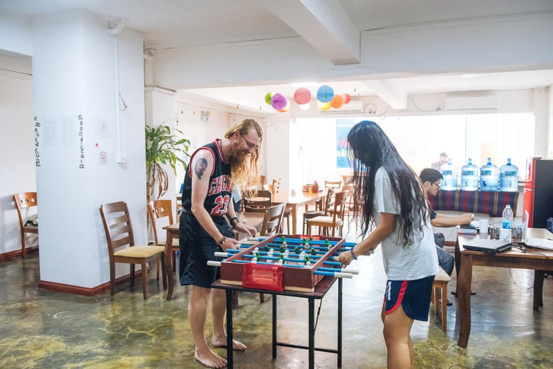 Backpackers playing foosball at a cheap hostel in Yangon