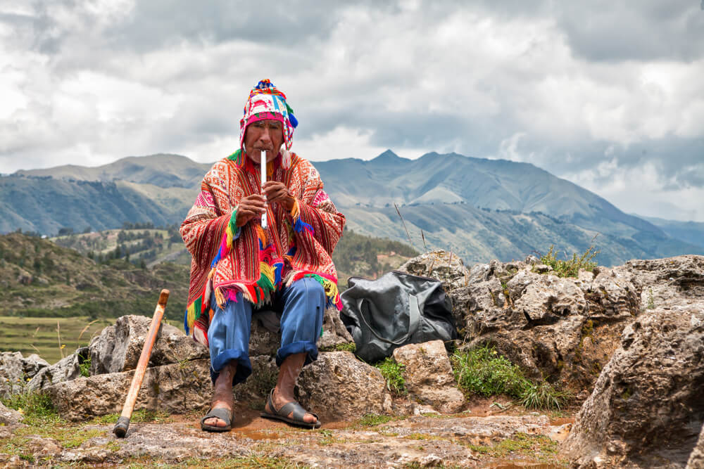 An old man in Peru playing the flute