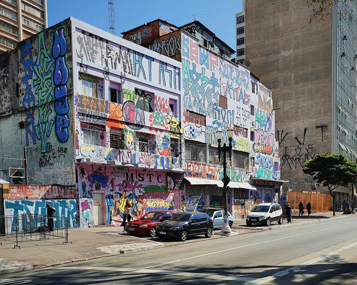 Building with colorful graffiti all over the front in a street in Sao Paulo city.