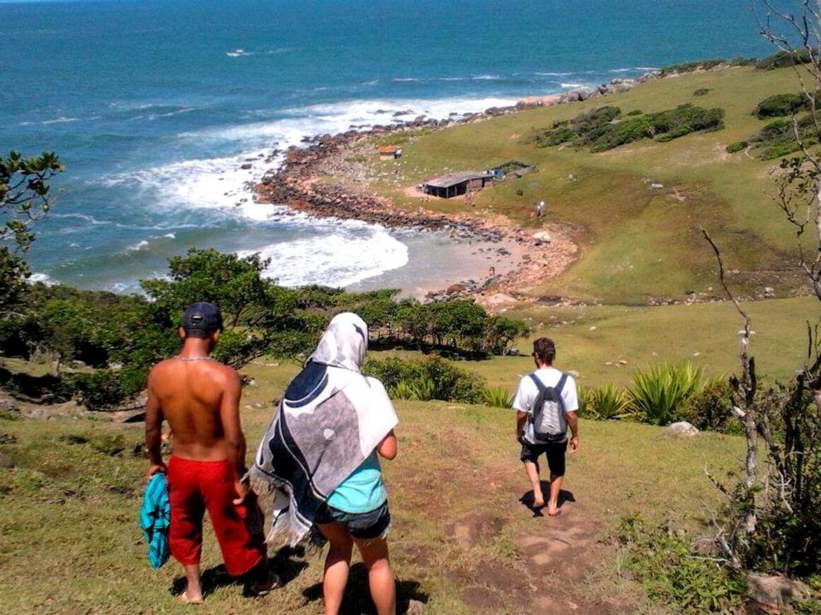 People walking on a hill heading to the coast line and the beach on a sunny day. 