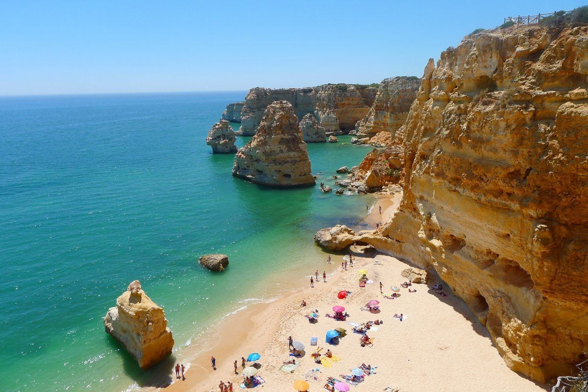 Sunny beach with sunbathers in algarve portugal