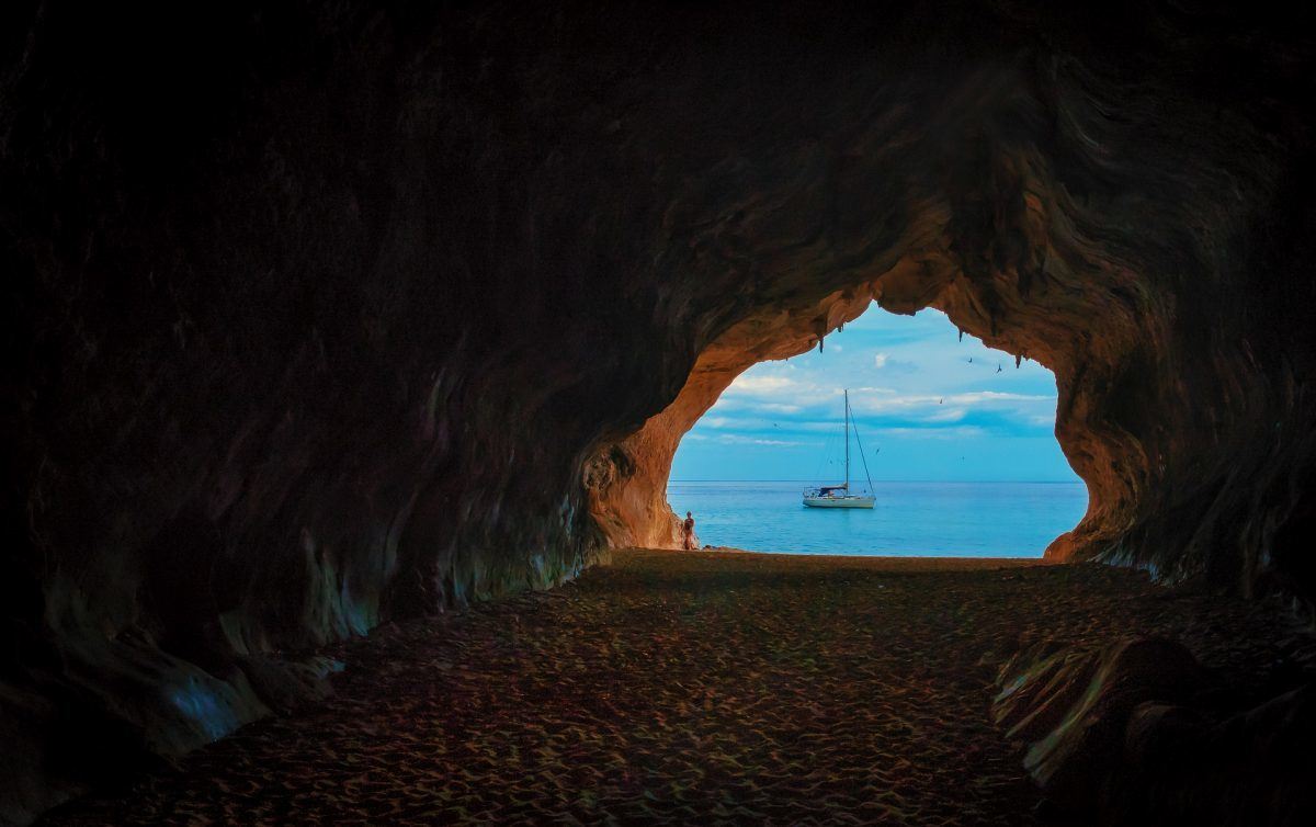 sailboat seen through the window of a grotto sardinia italy