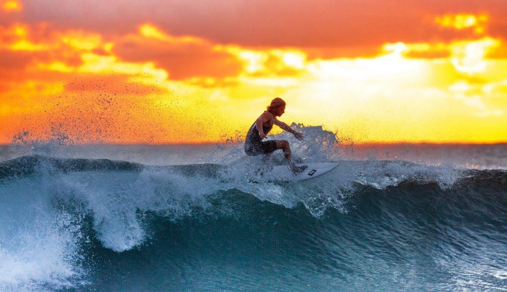 surfing in French Polynesia at sunset. 
