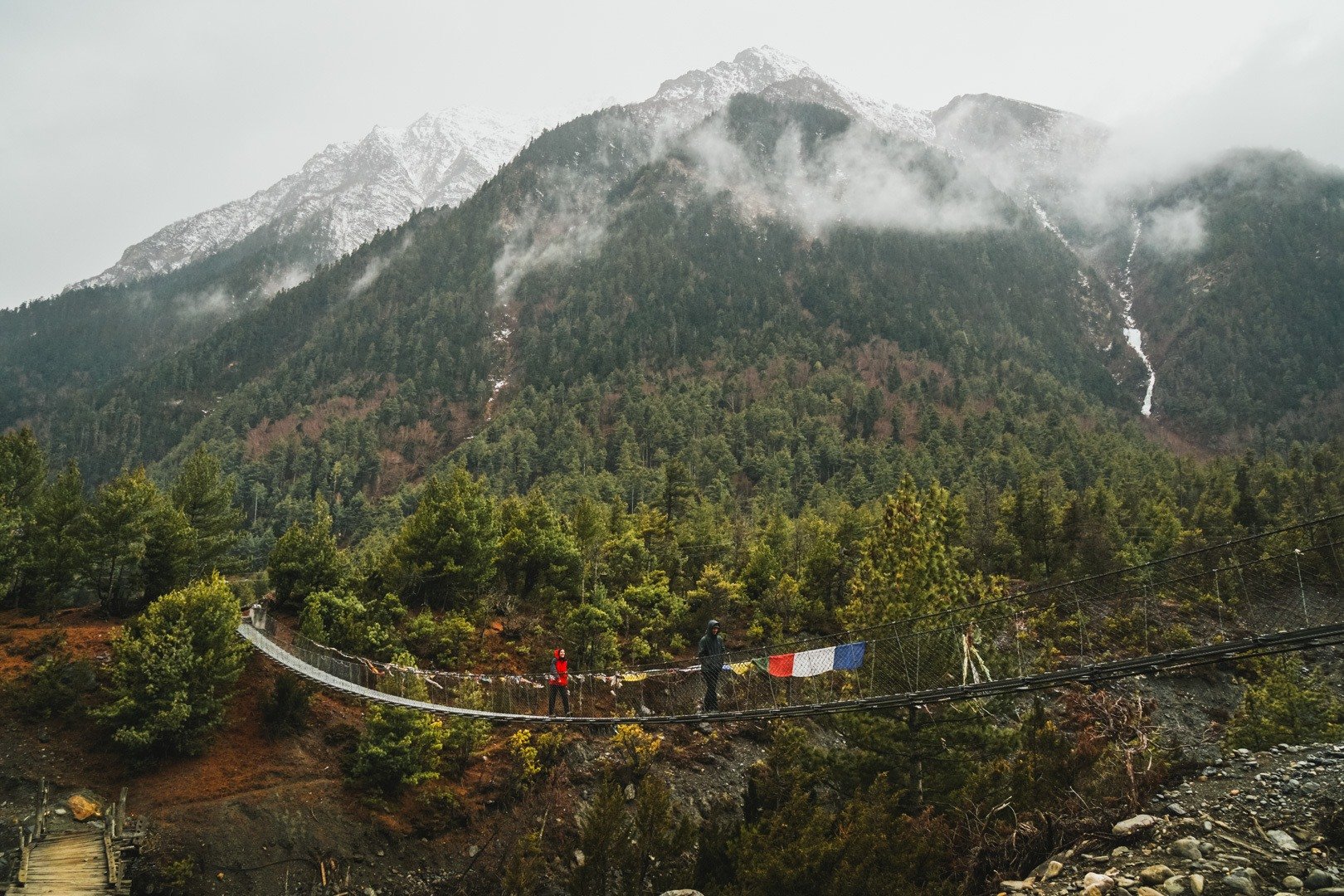 Crossing a foot bridge while trekking in Nepal