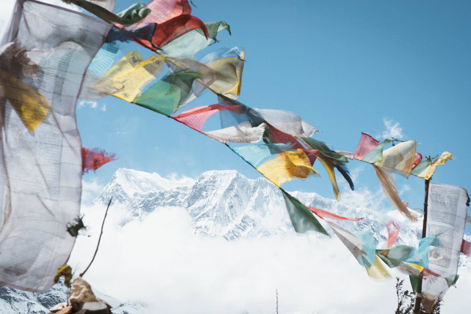 A snowcapped Himalayan peak with Tibetan prayer flags