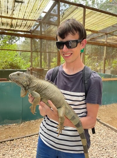 Alex holding a green iguana in San Ignacio, Belize.