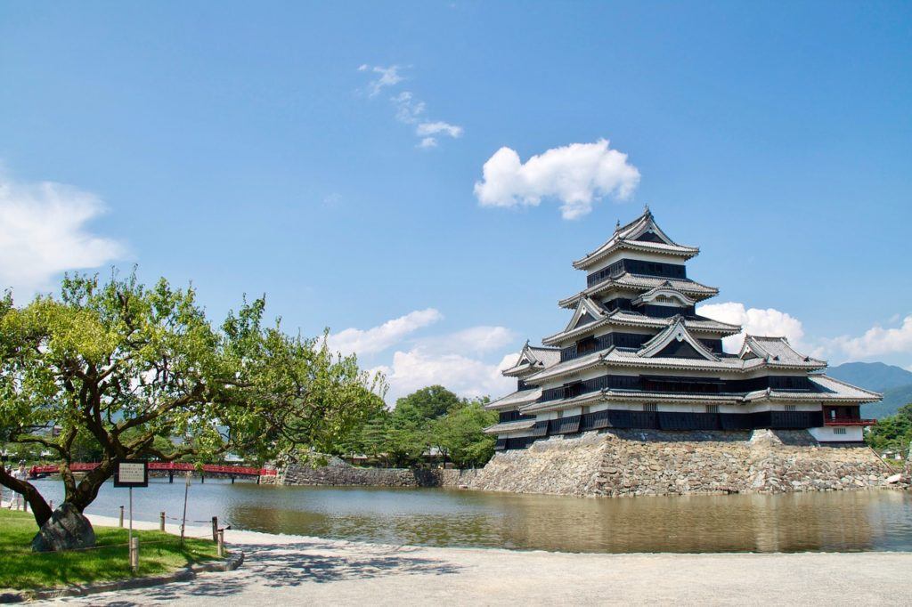 Matsumoto castle sits on a hill next to next to a river in Japan