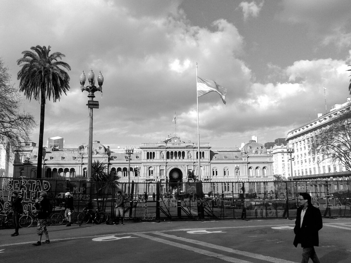 Black and white photo of Casa Rosada in Buenos Aires graffiti outside reading "libertad"