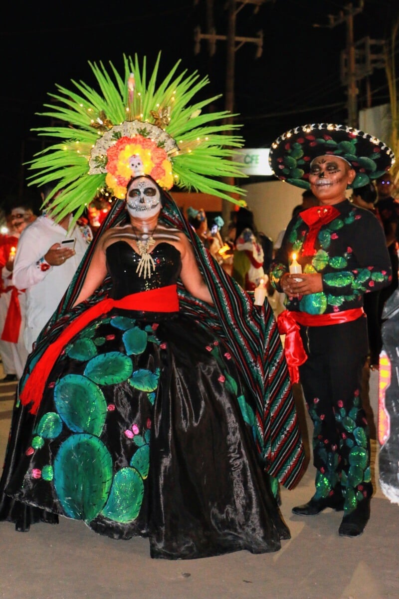 Two people with traditional dress and suit celebrating dia de los muertos.
