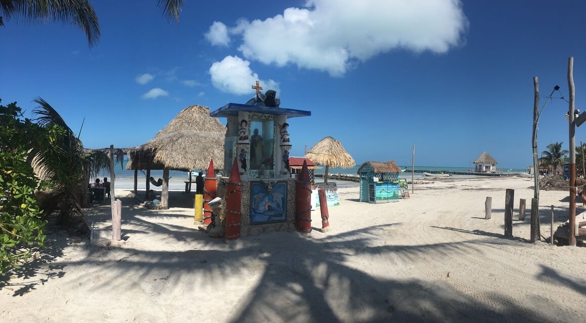 Mexican Caribbean beach with a religious altar and palapa constructions.