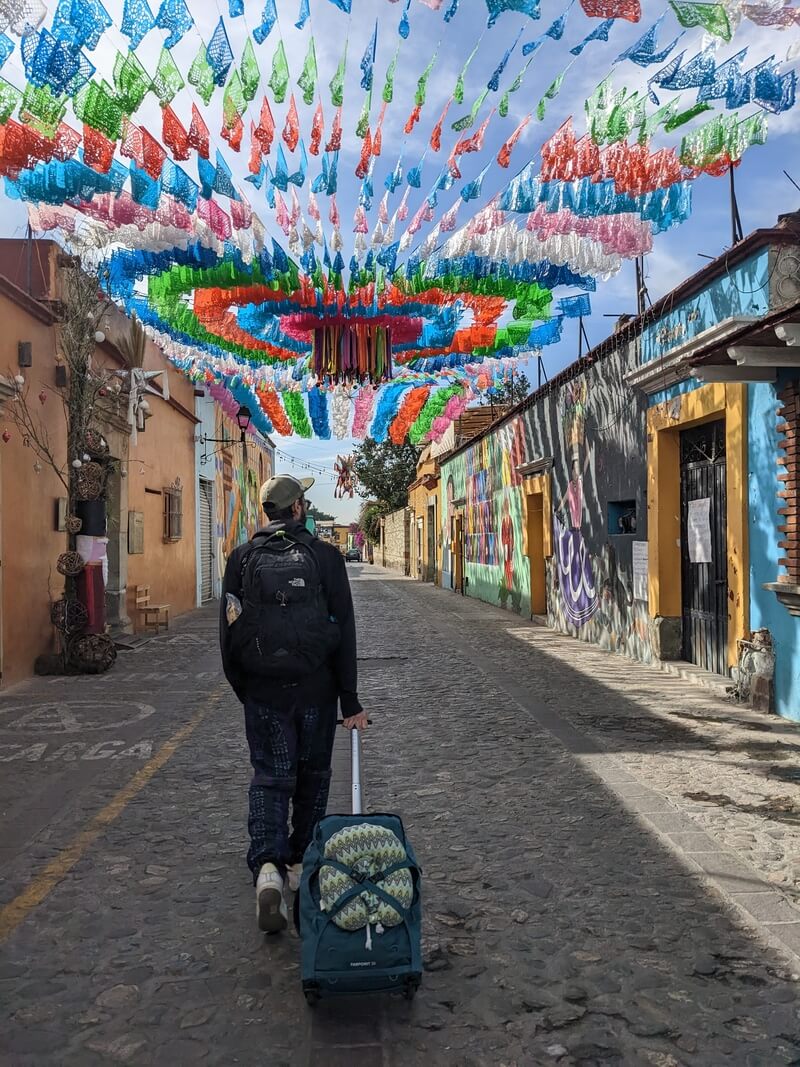 Tourist walking on a colourful street in Mexico.