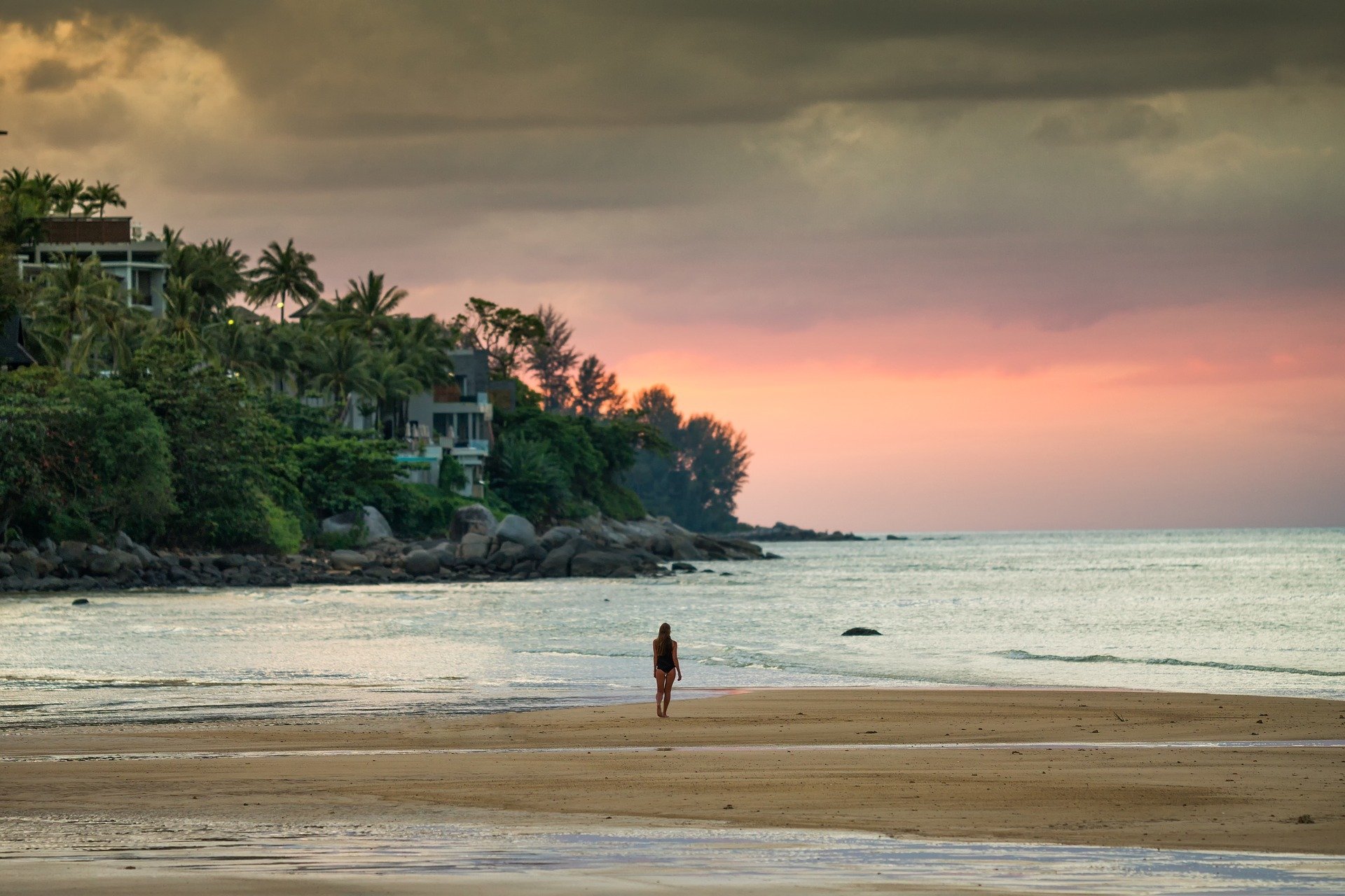 Watching the Sunset at Kamala beach.  A person walking on the beach. Phuket Thailand. 