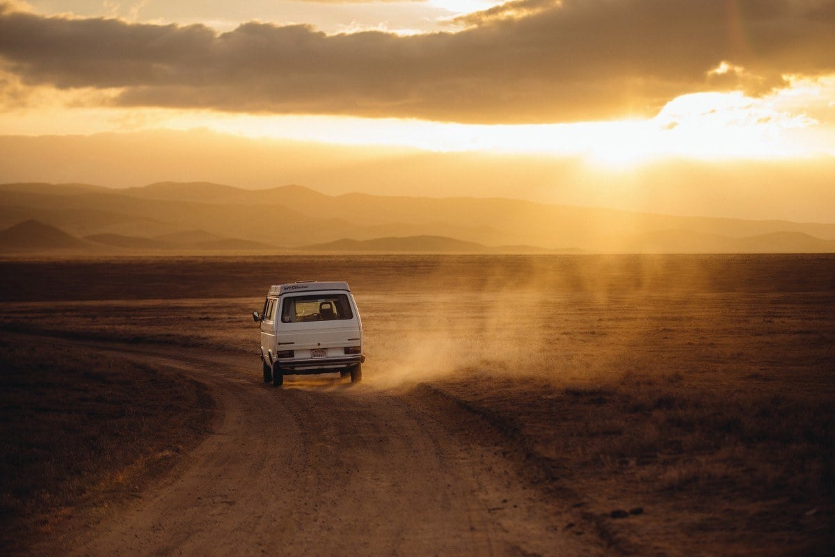 A van travelling into a desert sun