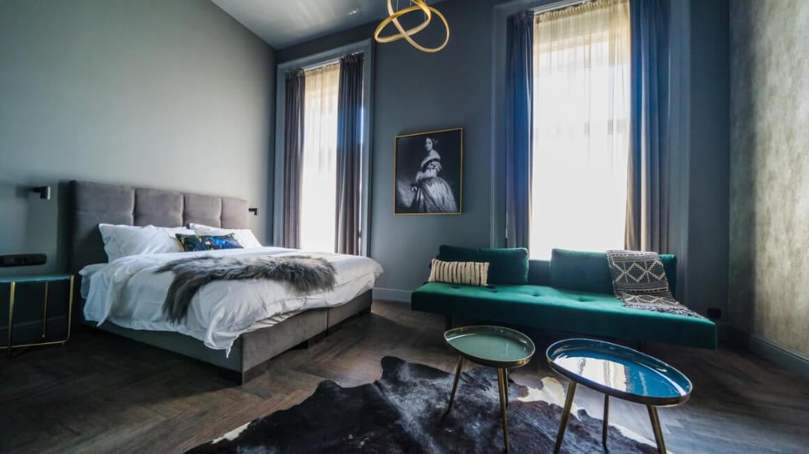 Bedroom with large windows, bed, couch and coffee tables