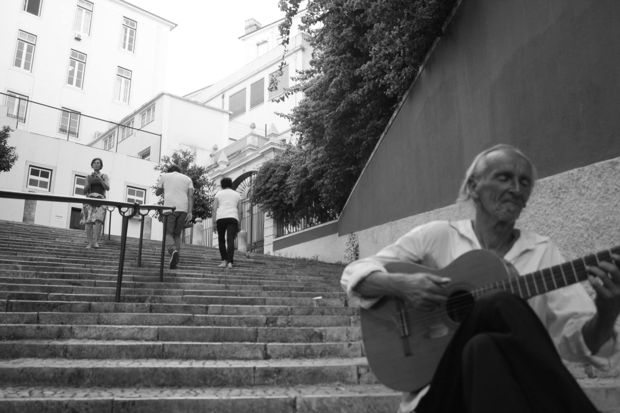 A man playing on his well-worn traveler classical guitar