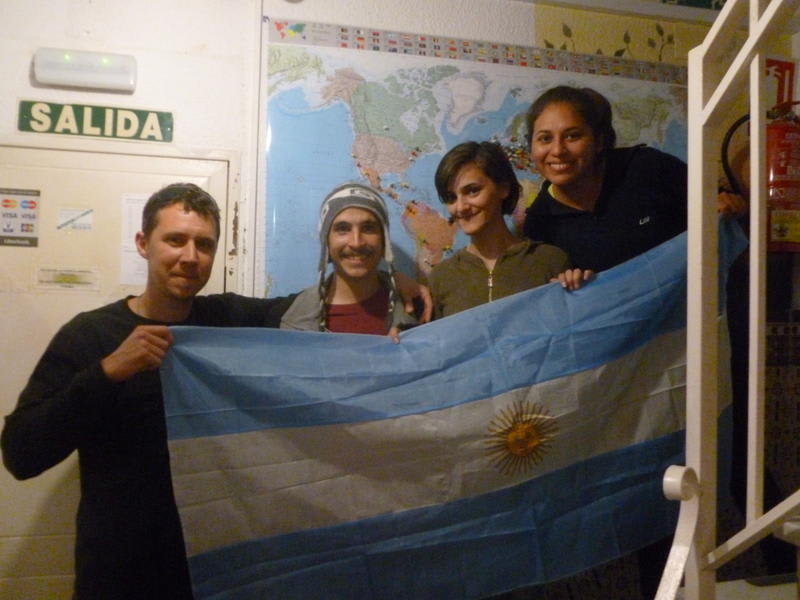 Hostal El Cascabel best hostels in Granada Spain, friends hold up a flag and smile for a photo