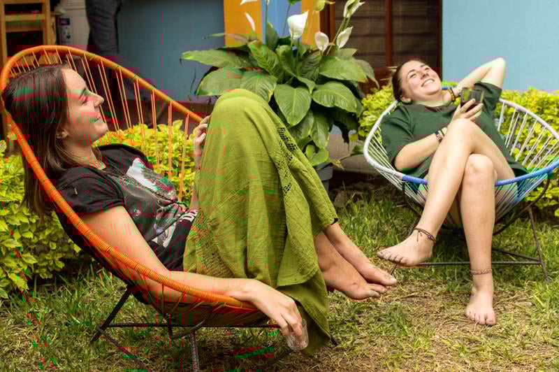 Azul Cielo Hostal best hostels in Oaxaca, two girls in comfy chairs in the garden laughing