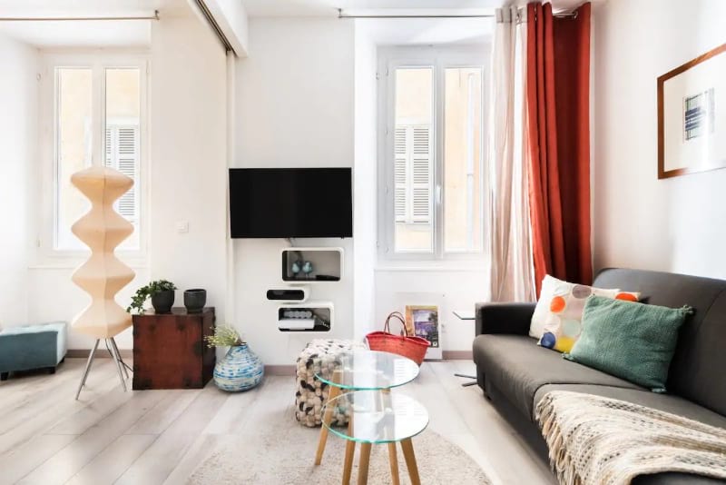 Bright living area with a couch, coffee table, TV and lovely high walls.