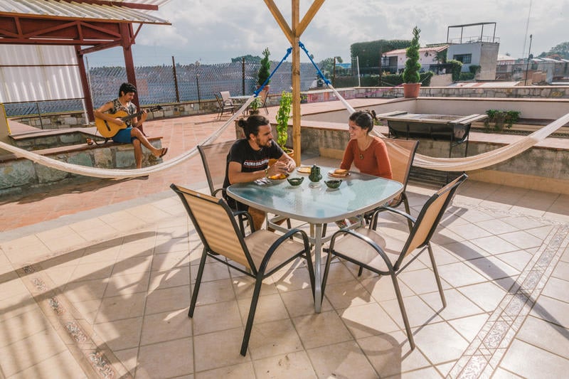 Hostal Chocolate best hostels in Oaxaca with a couple enjoying the rooftop terrace overlooking oaxaca city