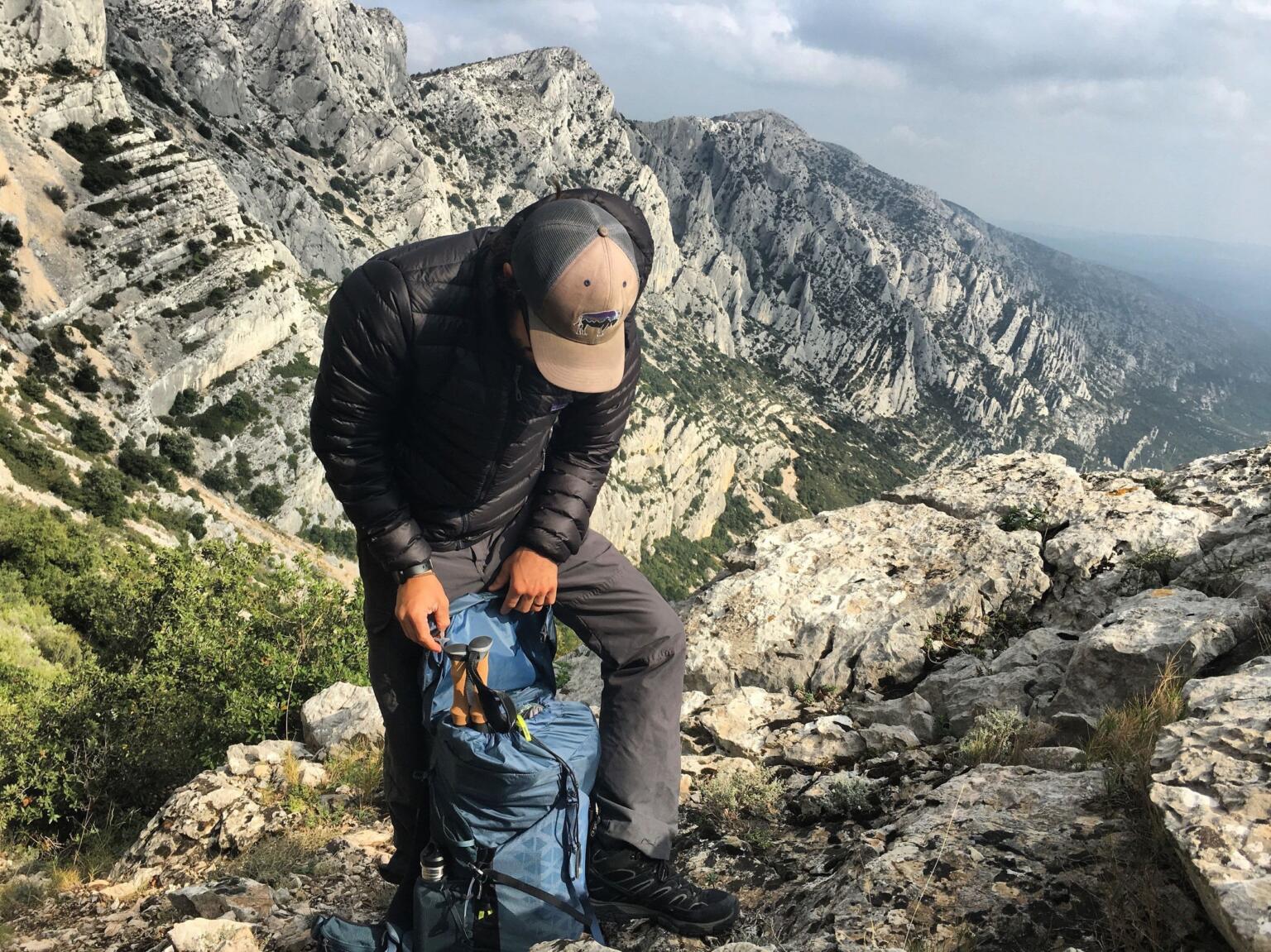 stowing trekking poles inside daypack