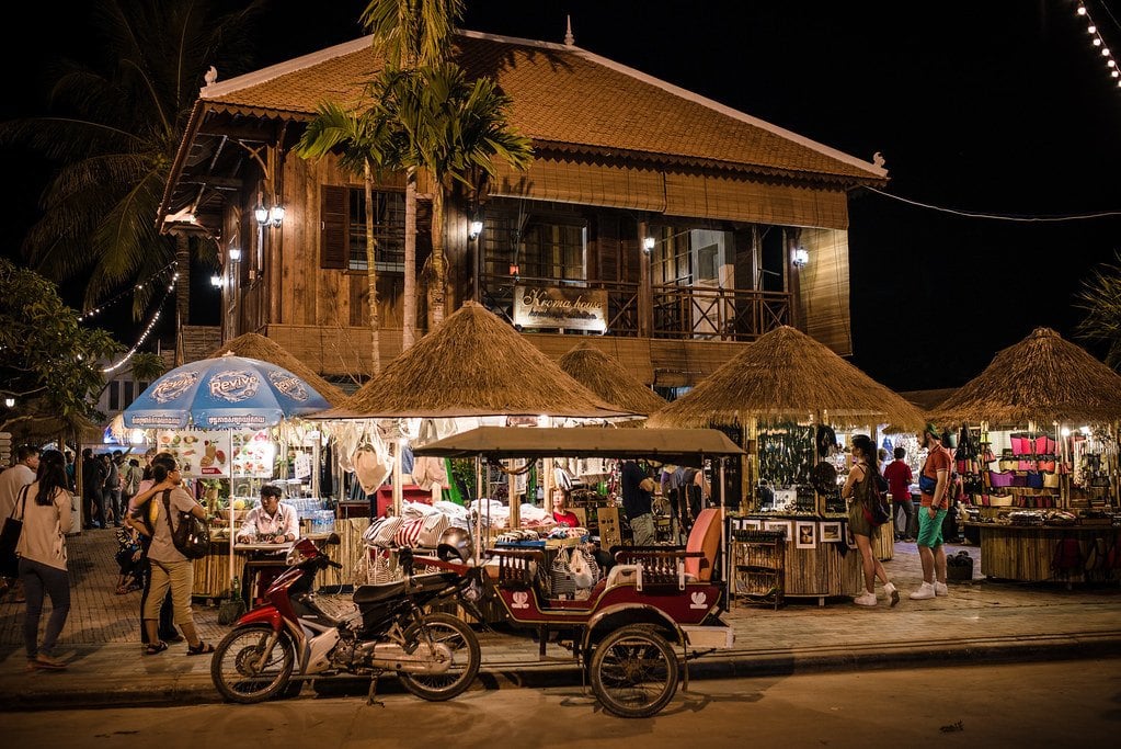 lit up stalls of siem reap's old market area with tourists visiting at night