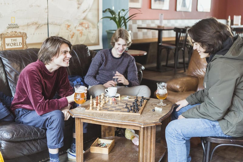 Snuffel Hostel best hostels in Bruges. friends play chess in the on site bar common room.