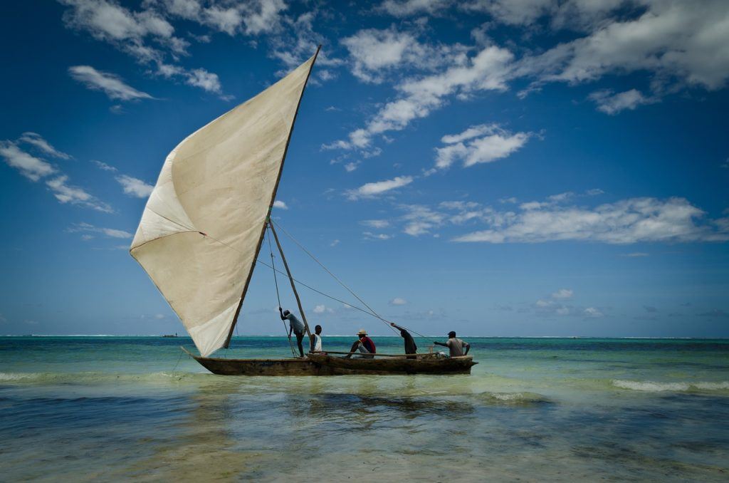 four men sailng a dhow (type of sailboat) 