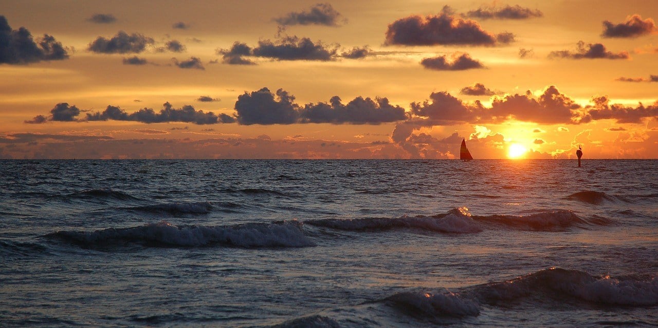 sunset florida with sailboat in water