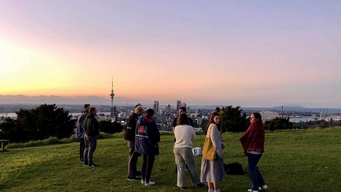dani and friends up the top of mount eden in auckland at sunset, new zealand