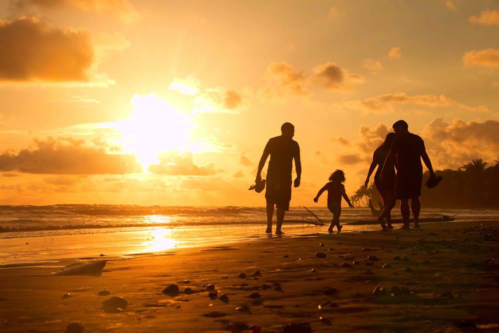 A family walks on the beach at sunset in Puerto Rico.