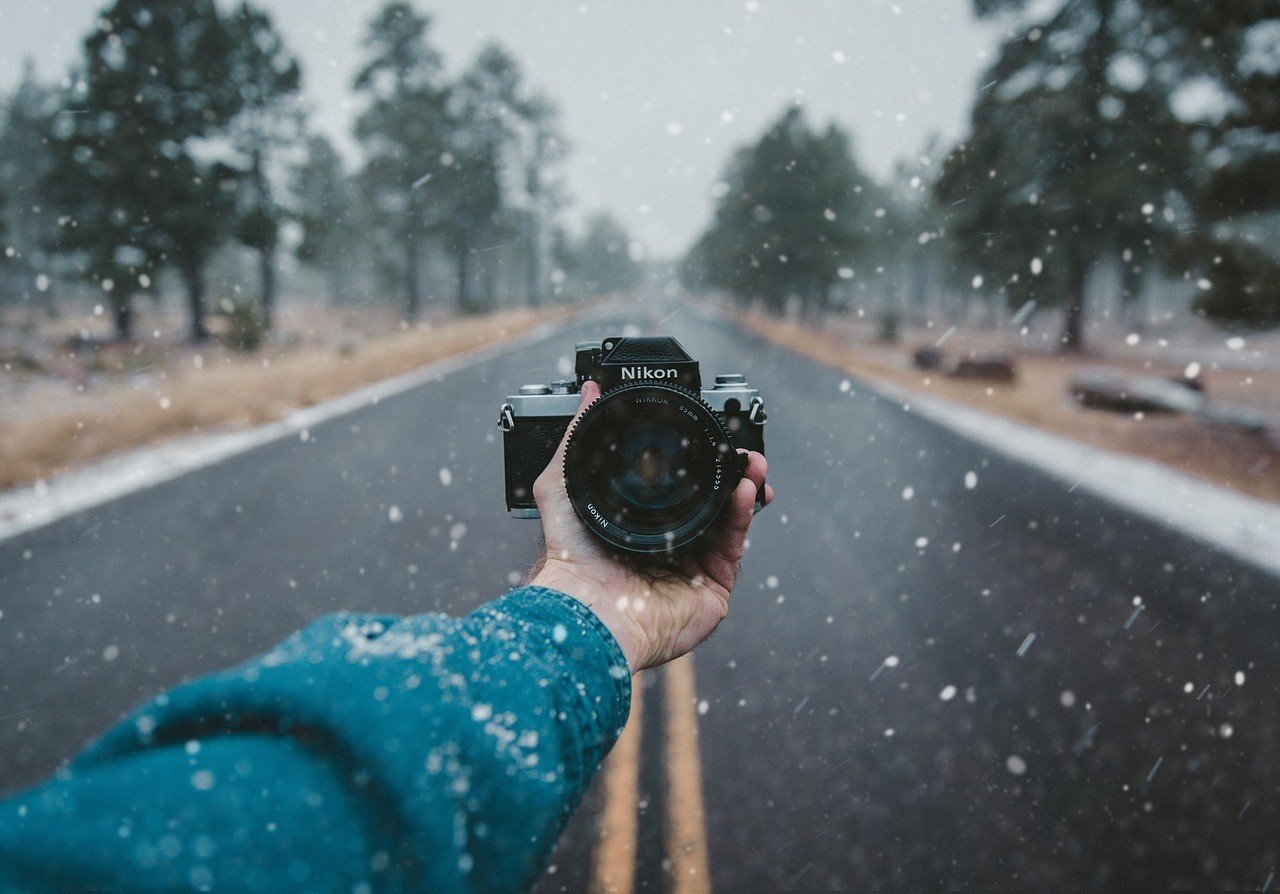 photographer holding out nikon camera