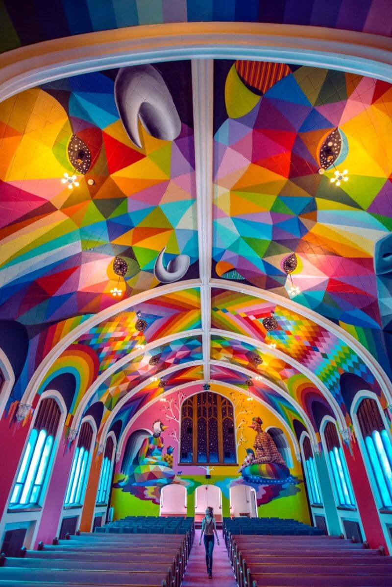 girl walking down the iasle in a kaleidescope colored church of cannabis denver