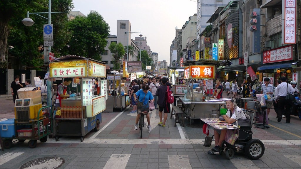 people walking around in the evening at a night market in Datong, Taipei