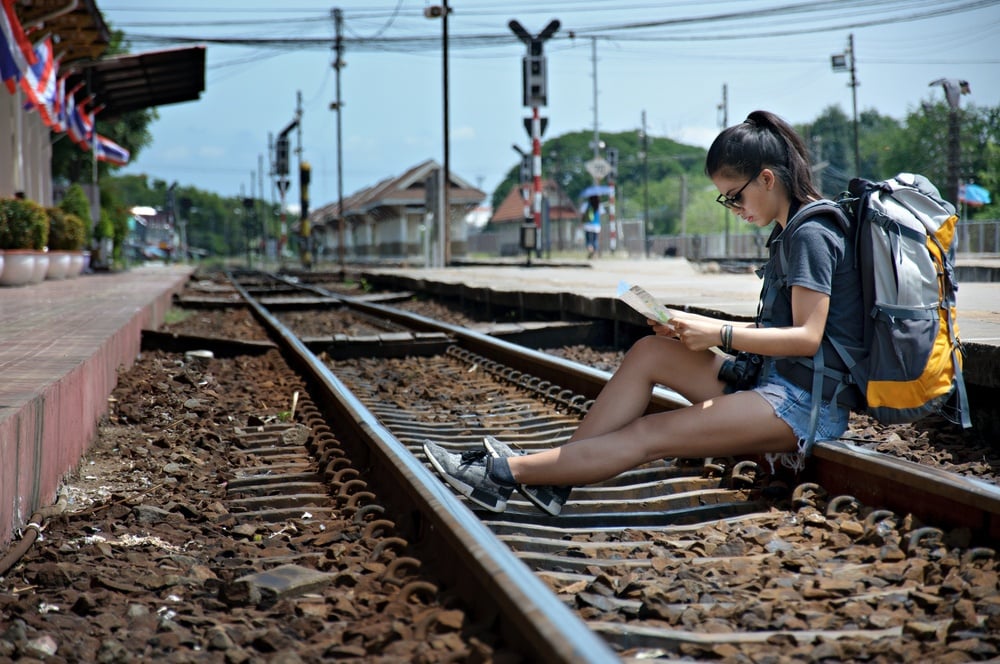 A solo backpacker in Malaysia waits for the train
