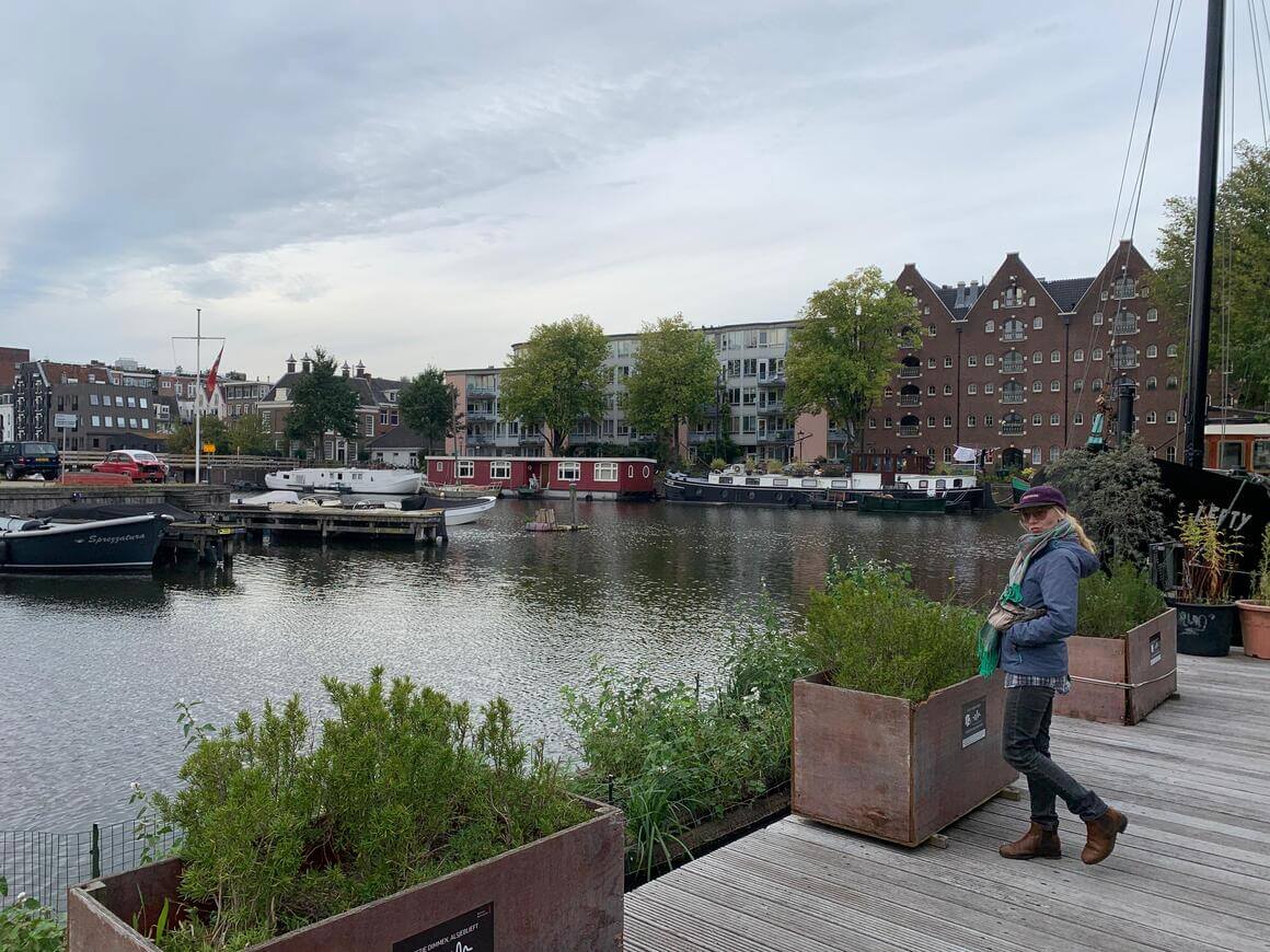 Laura stood on a wooden deck next to the canal in Amsterdam