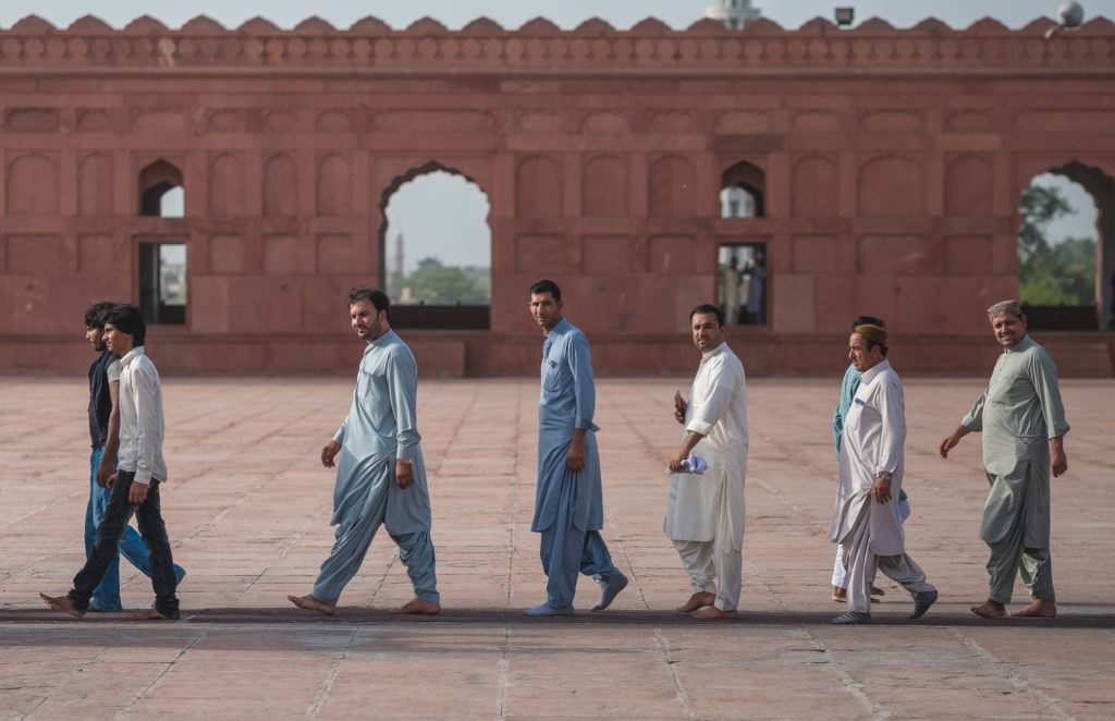 pakistani men walking at badshahi mosque pakistan